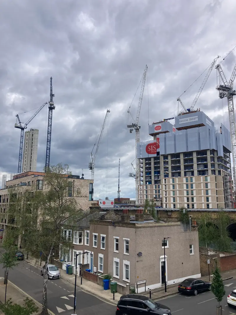 Tower cranes and new blocks rising behind a row of terraced houses in Bermondsey, south London