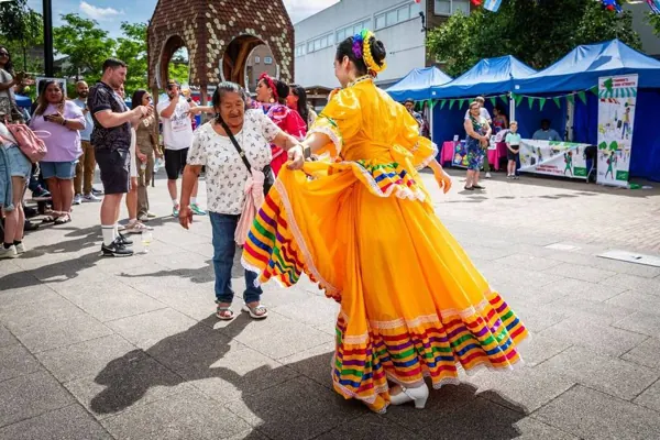 A dancer in a bright yellow dress at a Bermondsey street festival